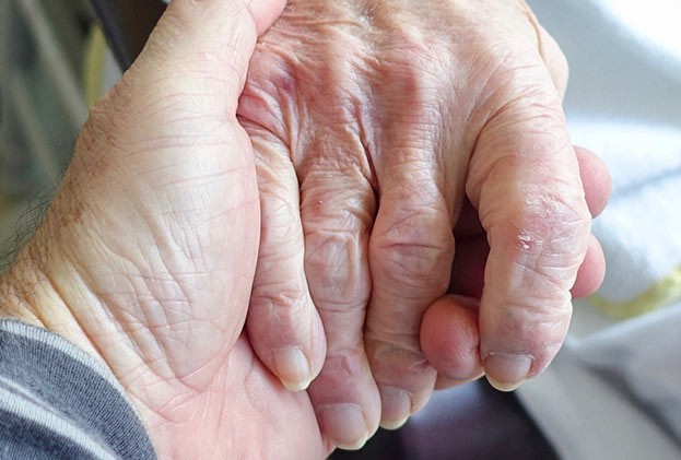 Eine jüngere Person hält die Hand einer älteren Person. Das gibt Senioren Kraft, wenn sie wissen, sie werden nicht alleine gelassen.