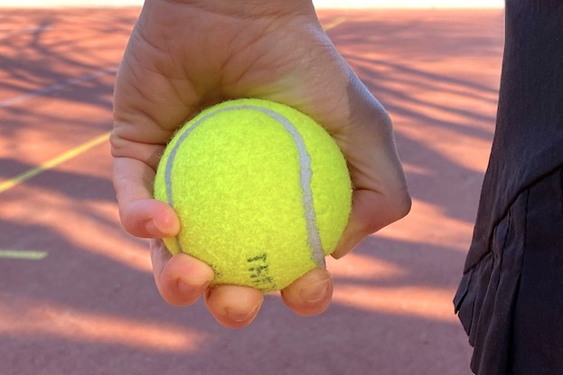 Hand, die einen Tennisball drückt 